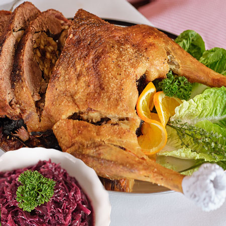 Gefüllter Gänsebraten mit Semmelknödel-Backpflaumenfüllung, Gänsesauce mit Rotwein und Apfel-Rotkohl. Fix und fertig vorbereitet und in nur 60 Minuten zuhause das gesamte Festmahl erwärmen. Bestellen im Lecker-Shop bei eskildsen.de
